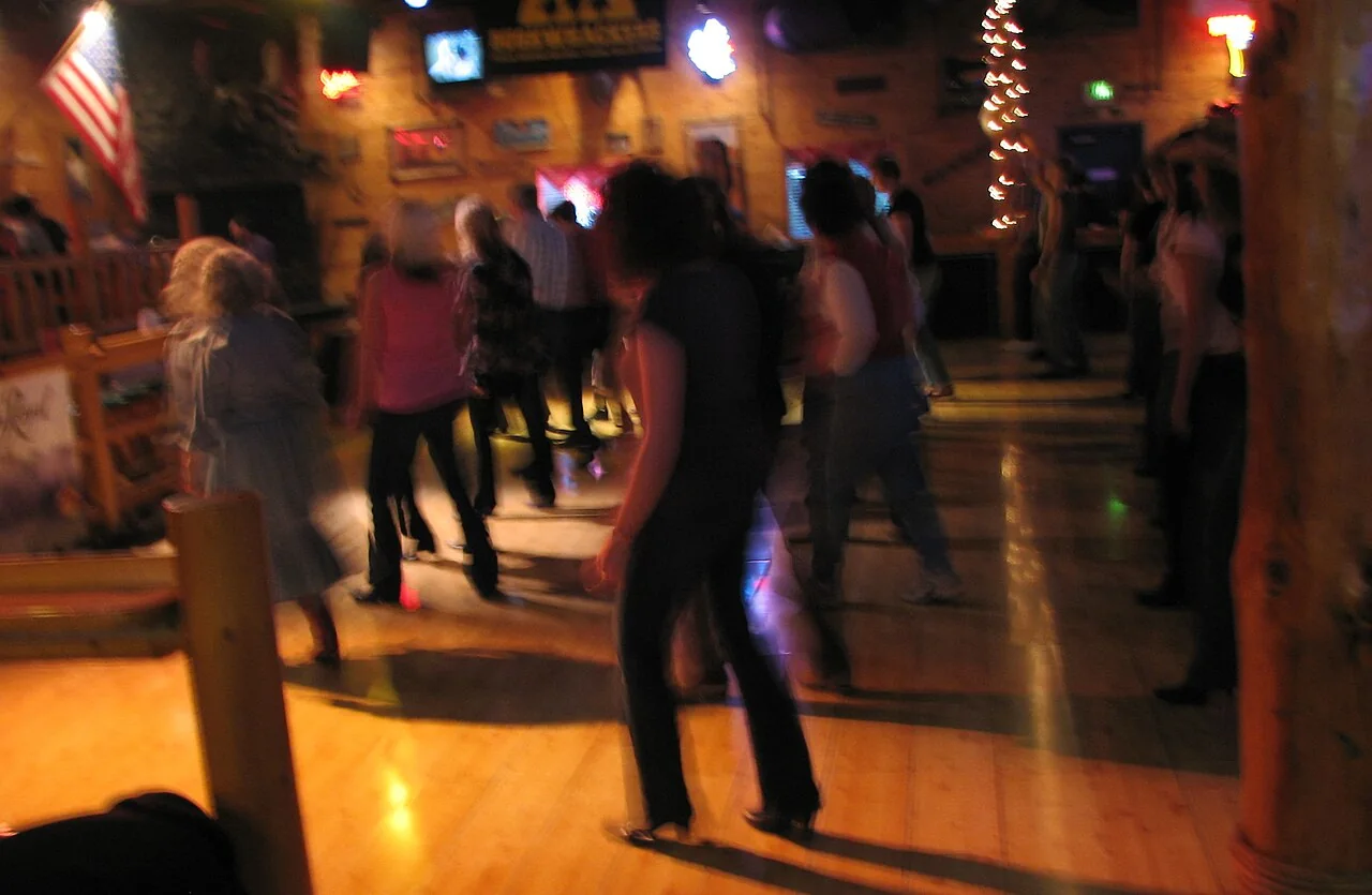 Groupe pratiquant la danse en ligne dans une salle country